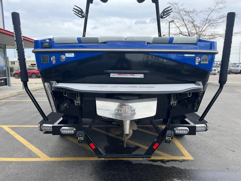 Slide: The Image of 2023 Axis T220 boat rear view in parking lot, showcasing propeller and swim platform. - 5