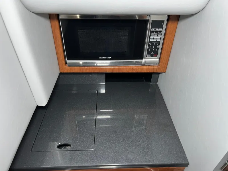 Slide: The Image of 2015 Formula 350 Crossover Bowrider interior with microwave and sleek countertop. - 25