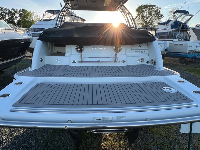 Slide: The Image of 2015 Formula 350 Crossover Bowrider with sunlit deck, docked among other boats. - 8