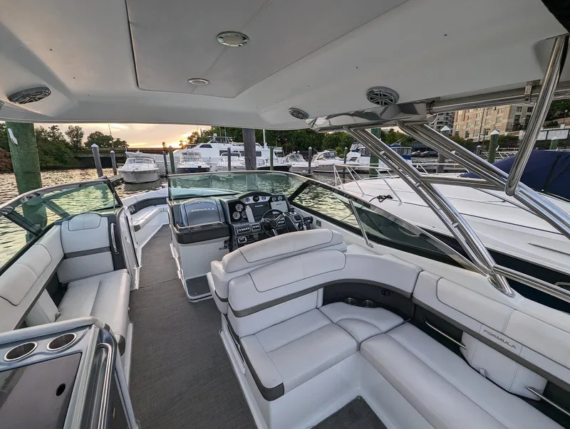 Slide: The Image of 2015 Formula 350 Crossover Bowrider with spacious seating docked at marina during sunset. - 9