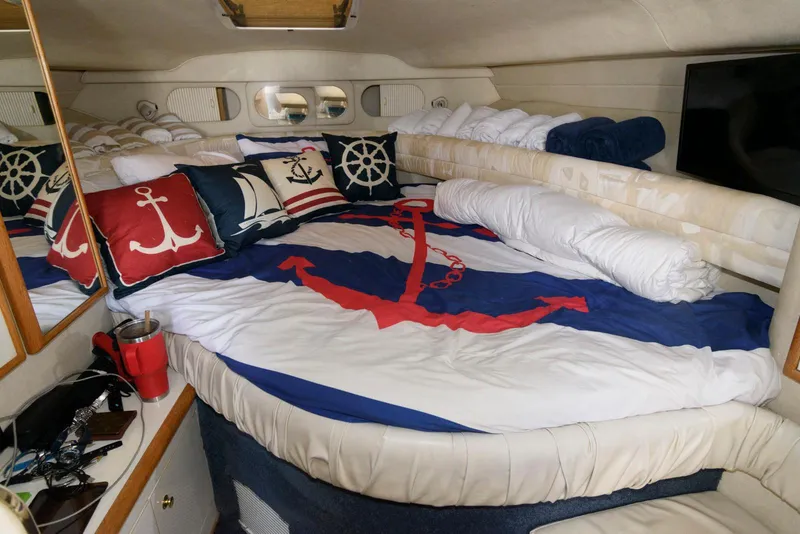 Slide: The Image of 1998 Sea Ray 330 Sundancer cabin with nautical-themed bedding and decor. - 12