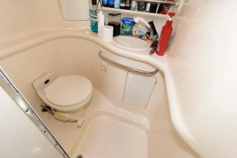 Slide: The Image of 1998 Sea Ray 330 Sundancer cabin interior with seating, pillows, and storage items. - 14