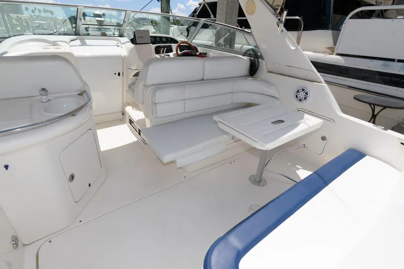 Slide: The Image of 1997 Sea Ray 330 Sundancer boat interior with blue and white seating and table. - 2