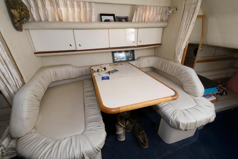 Slide: The Image of Interior of 1998 Sea Ray 330 Sundancer with seating, table, and sleeping area. - 9