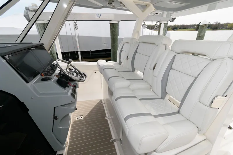 Slide: The Image of 2022 Pursuit S 378 Sport boat interior with luxurious white seating and modern helm. - 10