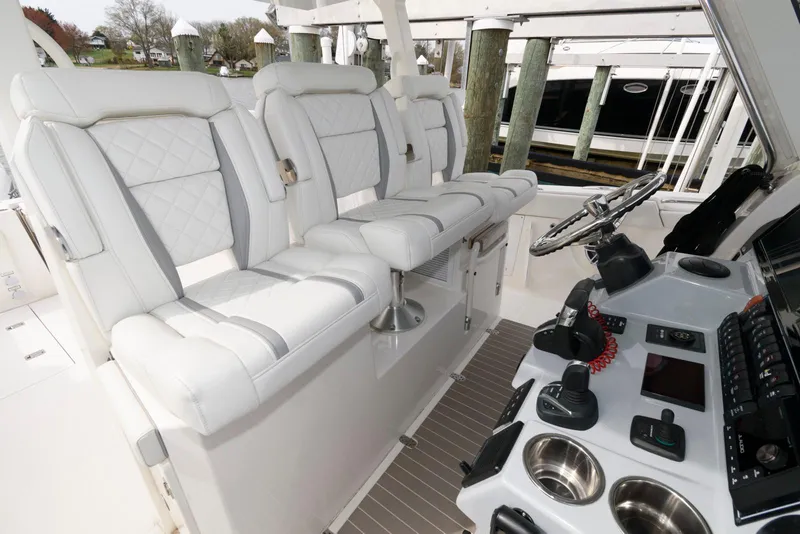 Slide: The Image of 2022 Pursuit S 378 Sport boat interior with white seating and modern controls. - 13