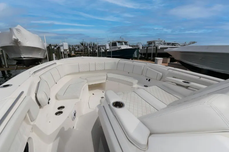 Slide: The Image of 2022 Pursuit S 378 Sport boat with spacious seating and sleek design at a marina. - 14