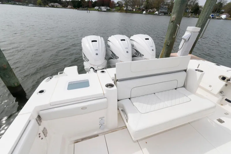 Slide: The Image of 2022 Pursuit S 378 Sport boat with triple engines and white seating by the water. - 18