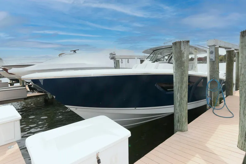 Slide: The Image of 2022 Pursuit S 378 Sport boat docked at marina under blue sky. - 2