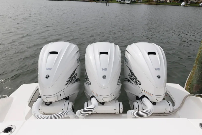 Slide: The Image of Triple V8 engines on a 2022 Pursuit S 378 Sport boat, docked by the water. - 20