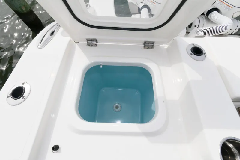 Slide: The Image of Open storage compartment on 2022 Pursuit S 378 Sport boat, featuring a blue interior. - 21