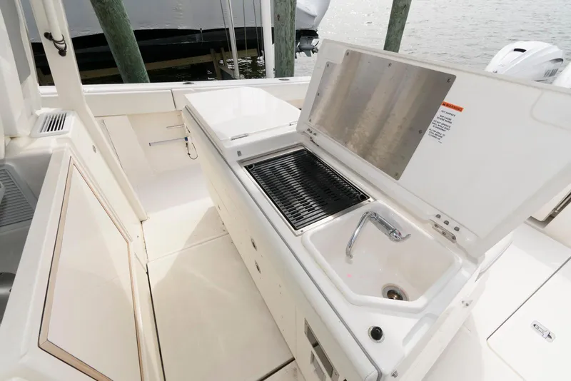 Slide: The Image of 2022 Pursuit S 378 Sport boat with outdoor sink and grill setup. - 23