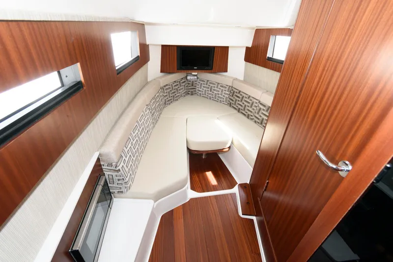 Slide: The Image of 2022 Pursuit S 378 Sport cabin interior with wood finish and seating area. - 24