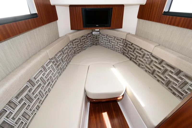 Slide: The Image of 2022 Pursuit S 378 Sport cabin with cushioned seating and a mounted TV. - 26