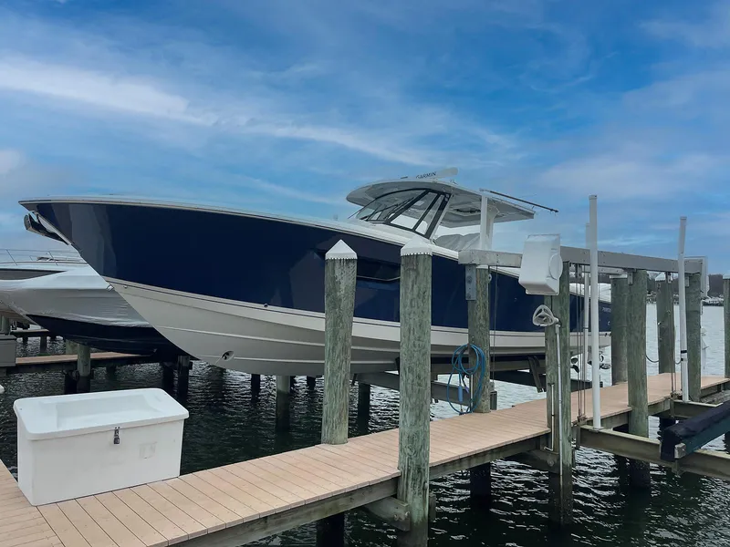 Slide: The Image of 2022 Pursuit S 378 Sport boat docked at marina under blue sky. - 3