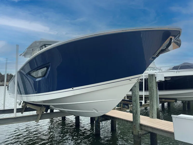 Slide: The Image of 2022 Pursuit S 378 Sport boat docked, featuring sleek blue and white design. - 4