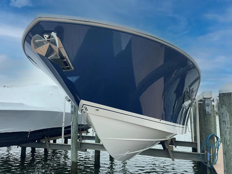 Slide: The Image of 2022 Pursuit S 378 Sport boat docked, showcasing sleek design and blue hull. - 5