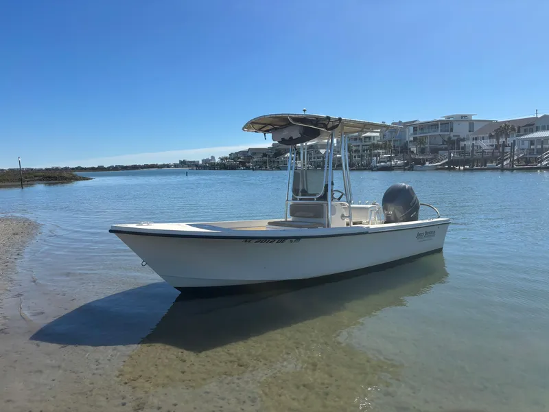 Slide: The Image of 2005 Jones Brothers 18 Cape Fisherman boat docked in calm waters under clear blue sky. - 19