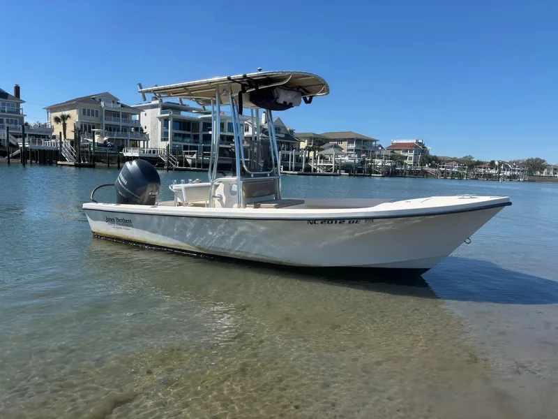 Slide: The Image of 2005 Jones Brothers 18 Cape Fisherman boat in calm waters near waterfront homes. - 2