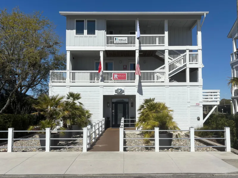 Slide: The Image of Three-story white building with balconies, palm trees, and clear blue sky. - 22