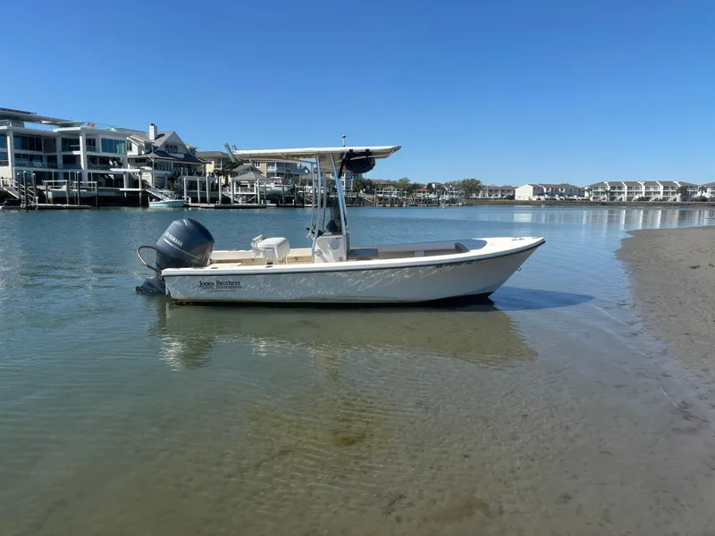Slide: The Image of 2005 Jones Brothers 18 Cape Fisherman boat in calm waters near waterfront homes. - 4