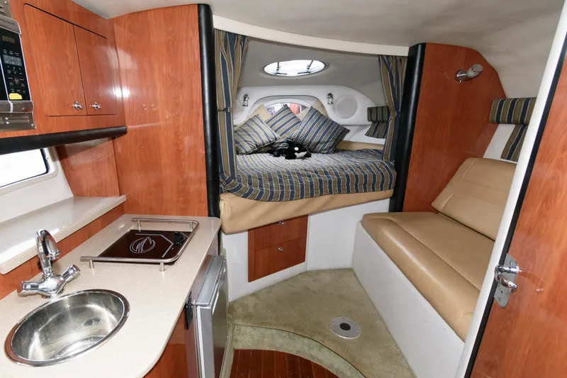 Slide: The Image of Interior of 2014 Crownline 294 CR boat with kitchenette and cozy sleeping area. - 15