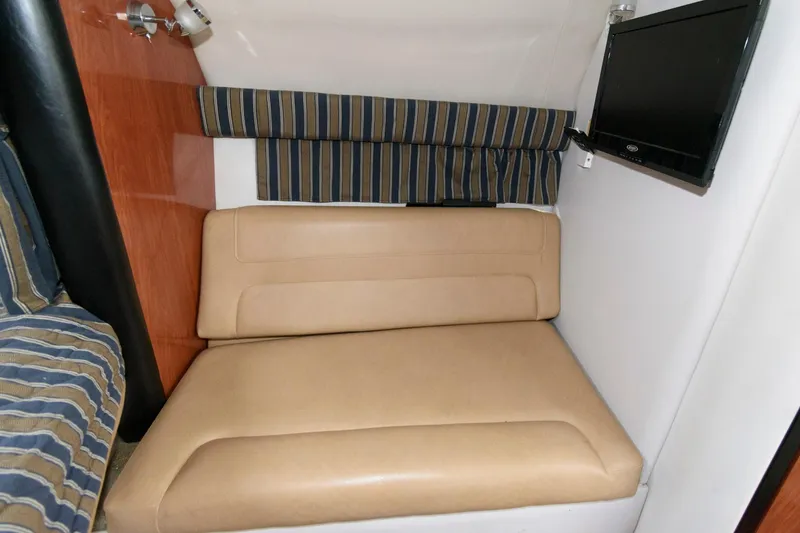 Slide: The Image of 2014 Crownline 294 CR cabin interior with beige seating and wall-mounted TV. - 18