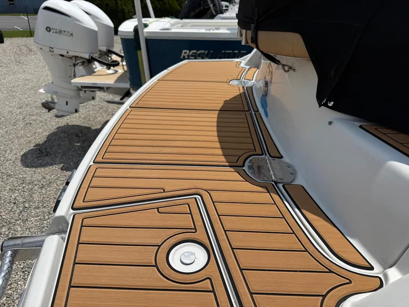 Slide: The Image of 2014 Crownline 294 CR boat with teak-style deck, docked near other vessels. - 2