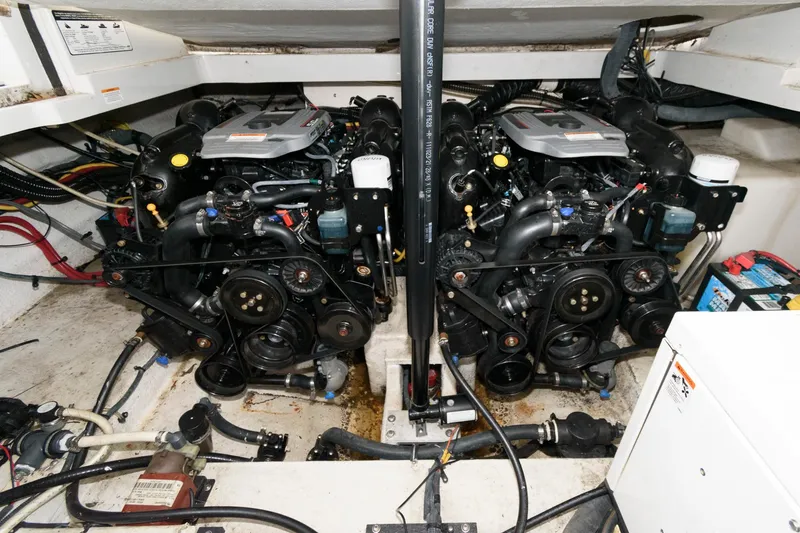 Slide: The Image of Engine compartment of a 2014 Crownline 294 CR boat, showcasing dual engines and mechanical components. - 21