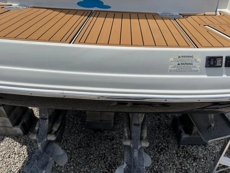 Slide: The Image of 2014 Crownline 294 CR boat on stands, featuring teak-style decking. - 3