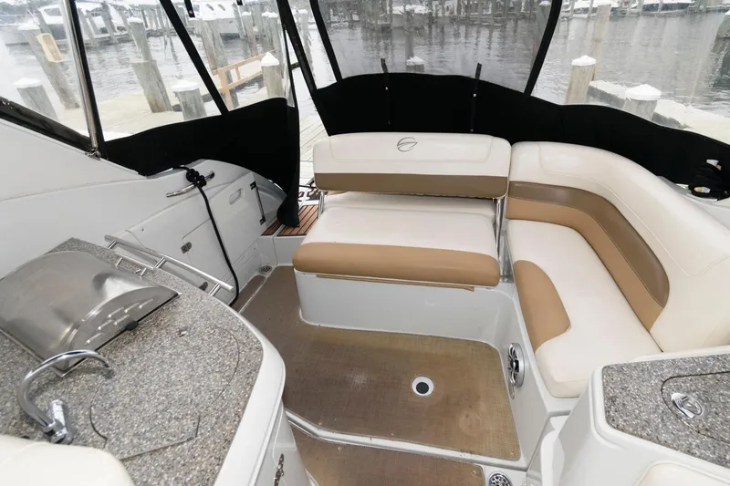 Slide: The Image of Interior of 2014 Crownline 294 CR boat with beige seating and kitchenette. - 6