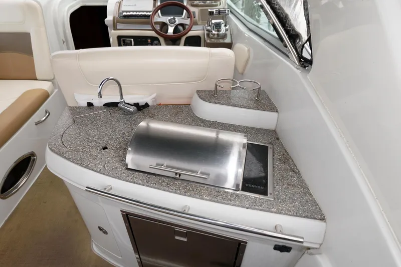 Slide: The Image of 2014 Crownline 294 CR boat interior with kitchenette and steering area. - 7
