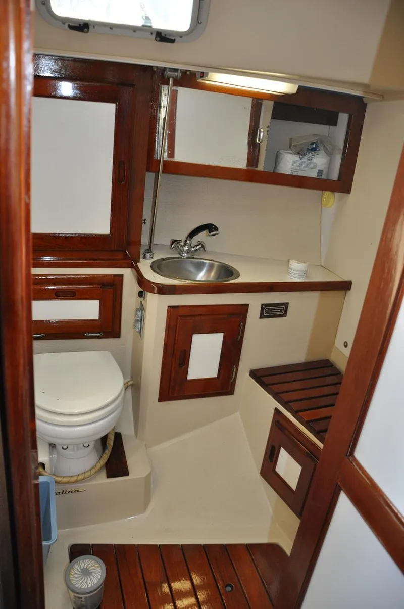 Slide: The Image of 1987 Catalina 36 Tall Rig yacht bathroom with wooden cabinetry and compact design. - 14