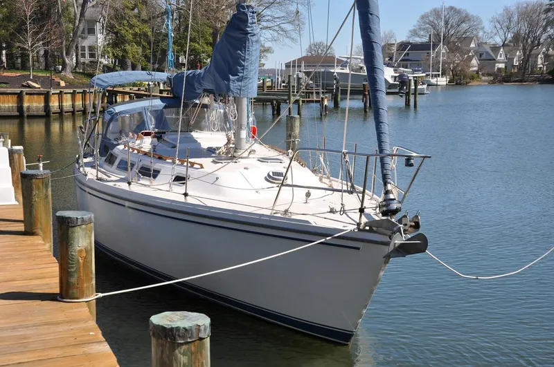 Slide: The Image of 1987 Catalina 36 Tall Rig sailboat docked in a serene marina setting. - 2