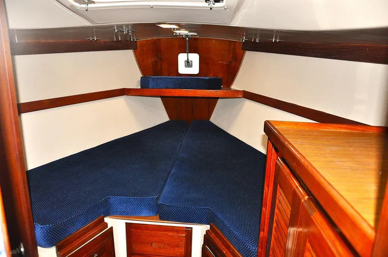 Slide: The Image of 1987 Catalina 36 Tall Rig cabin interior with blue cushions and wooden cabinetry. - 26