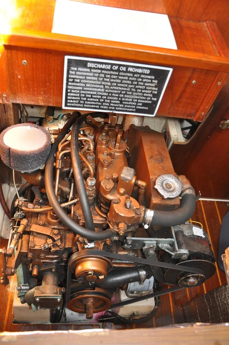 Slide: The Image of 1987 Catalina 36 Tall Rig engine compartment with visible components and warning sign. - 27