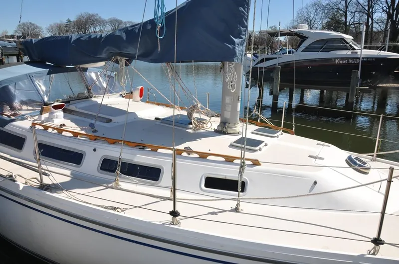 Slide: The Image of 1987 Catalina 36 Tall Rig sailboat docked in a marina, featuring a sleek white deck. - 5