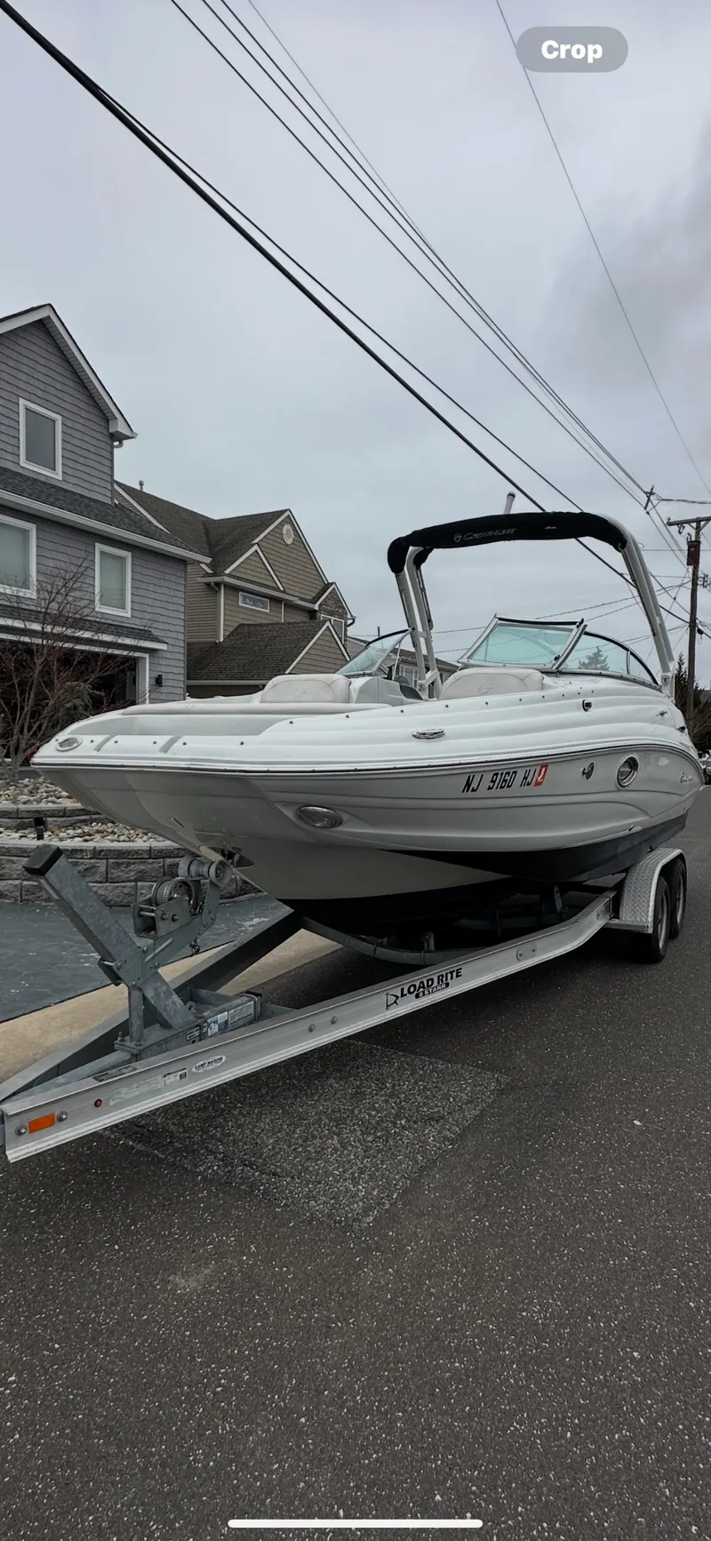 Slide: The Image of 2018 Crownline Eclipse E24 XS boat on trailer, parked on residential street. - 7