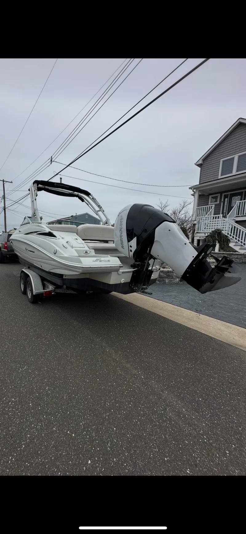 Slide: The Image of 2018 Crownline Eclipse E24 XS boat on trailer, parked on residential street. - 8