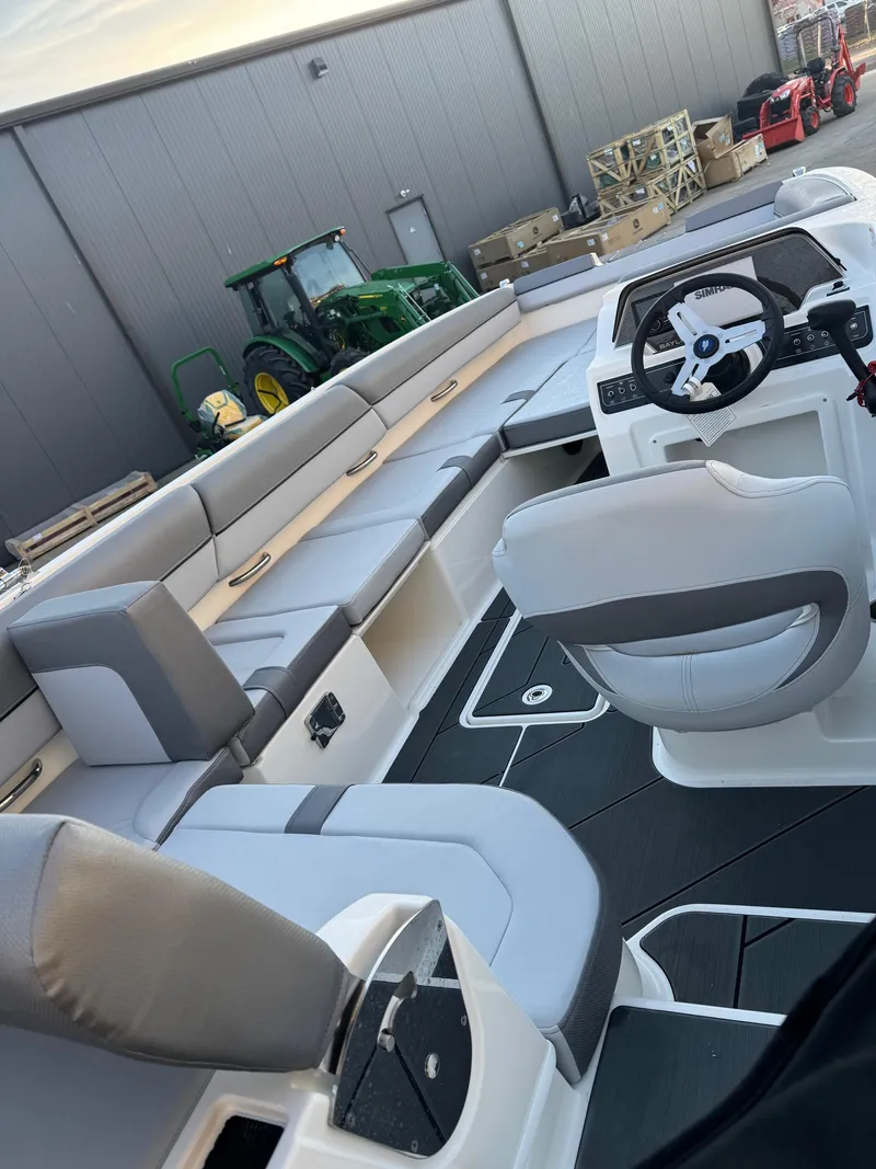 Slide: The Image of 2025 Bayliner D20 boat interior with modern seating and steering wheel. - 18