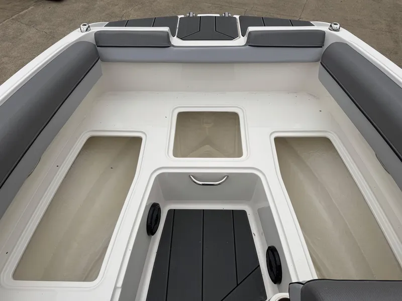 Slide: The Image of 2025 Bayliner D20 boat interior with gray seating and storage compartments. - 20