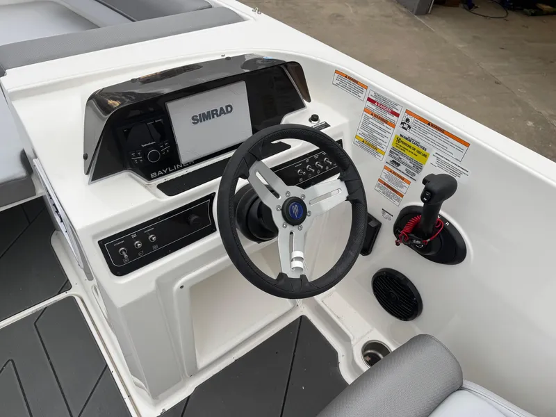 Slide: The Image of 2025 Bayliner D20 boat dashboard with Simrad display and steering wheel. - 21