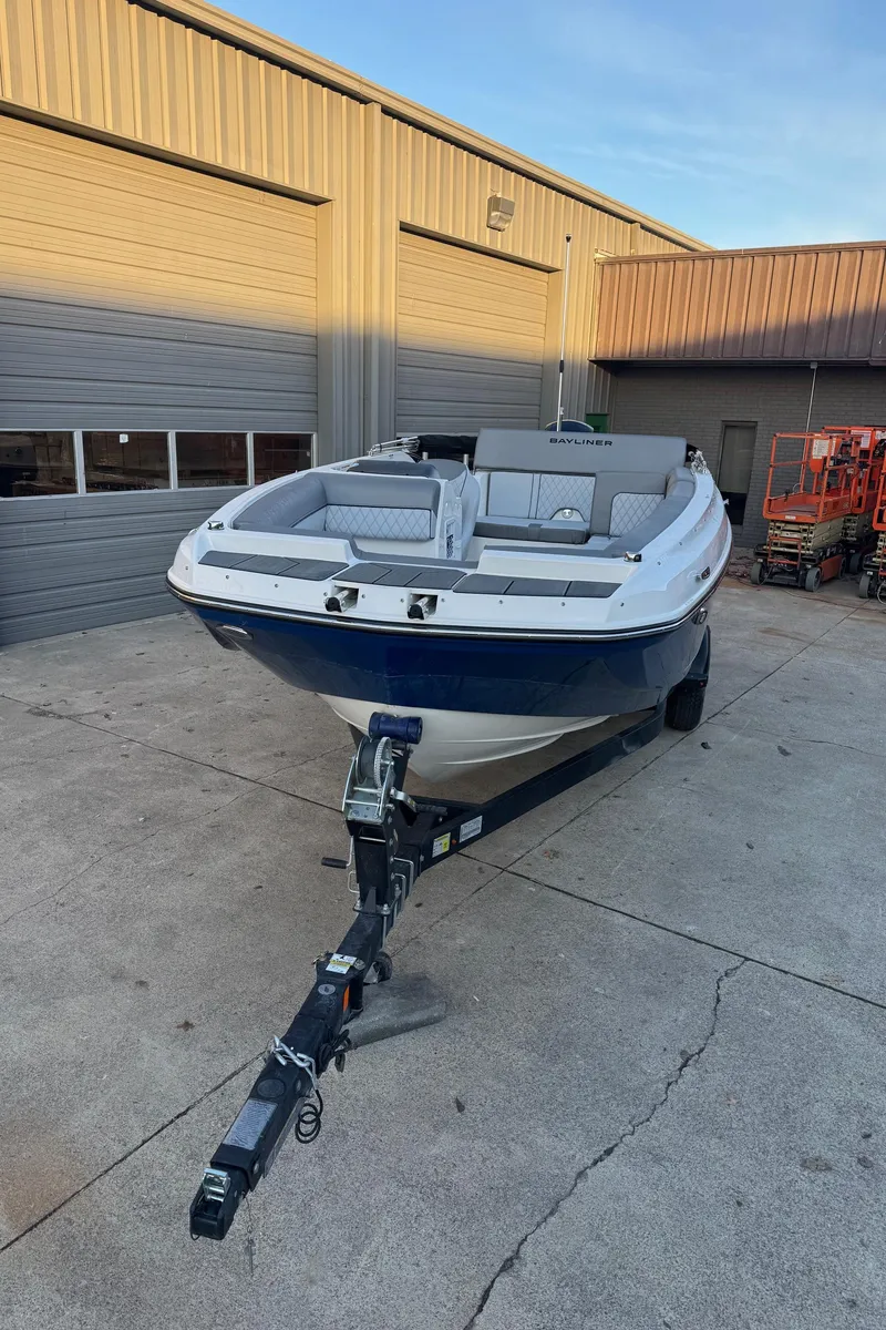 Slide: The Image of 2025 Bayliner D20 boat on trailer outside a garage. - 4