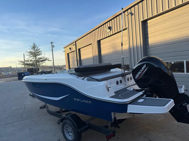 Slide: The Image of 2025 Bayliner D20 boat with Mercury engine, parked outside a warehouse. - 6