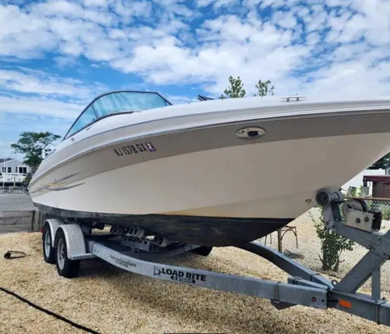 Slide: The Image of 2005 Four Winns 230 Horizon boat on trailer under a blue sky. - 6
