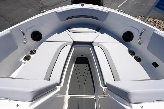 Slide: The Image of 2025 Bayliner V20i boat interior with white seating and cup holders. - 11