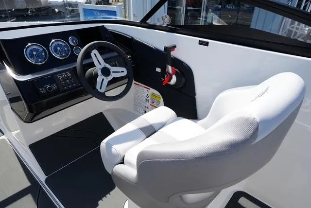 Slide: The Image of 2025 Bayliner V20i boat cockpit with steering wheel and white captain's chair. - 15