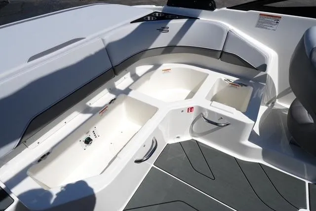 Slide: The Image of 2025 Bayliner V20i boat interior with open storage compartments and sleek seating design. - 19