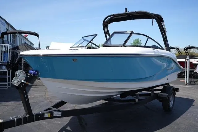 Slide: The Image of 2025 Bayliner V20i boat on trailer, blue and white design, parked outdoors. - 4