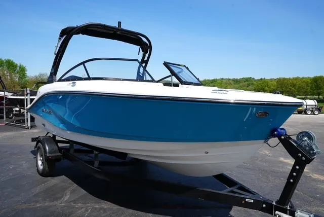 Slide: The Image of 2025 Bayliner V20i boat on trailer, blue and white design, parked outdoors. - 5